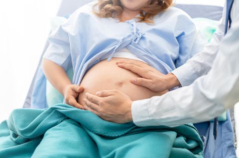 Eipollösung: Schwangere im Kittel wird von Arzt abgetastet