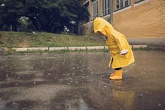 Kind spielt im Regen