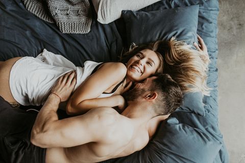Lusttropfen: Paar liegt kuschelnd im Bett
