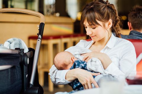 Öffentliches Stillen: eine Frau stillt ihr Baby in einem Café