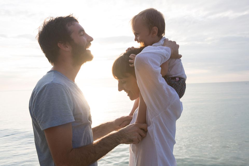Überraschende Studie: Mutter und Vater mit Kind am Strand