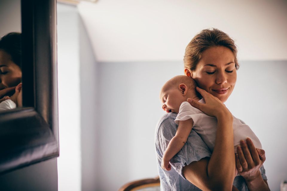 Verhaltensmuster: Mutter beruhigt Baby auf dem Arm