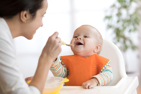 Eine Mutter füttert ihr Baby mit einem Brei.
