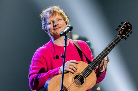 Ed Sheeran: Ed Sheeran in einem pinken Pullover und Gitarre