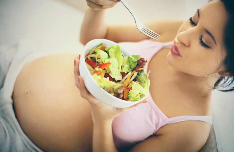 Schwangere Frau isst ein Salat