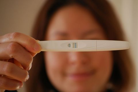 Frau hält Schwangerschaftstest