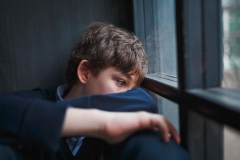 Erziehungstipps: Junge schaut gelangweilt aus Fenster