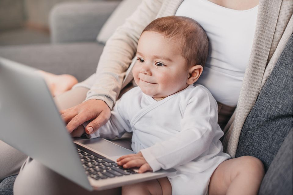 Frau mit Baby am Laptop